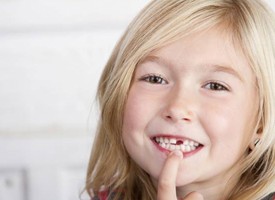 girl smiling with lost tooth