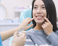 woman and dentist both pointing to smile
