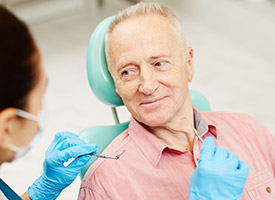 man in peach shirt looking at dentist