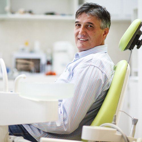 Man smiling while sitting in treatment chair