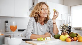 Woman smiling while enjoying snack in kitchen