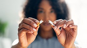 Closeup of woman breaking cigarette