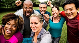 Diverse group of adults outside smiling for a selfie