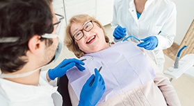 Senior woman smiling at dentist in treatment chair