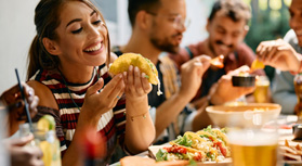 Woman smiling while eating lunch with friends at restaurant