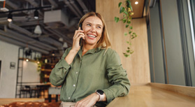 Woman smiling while talking on phone in cafe