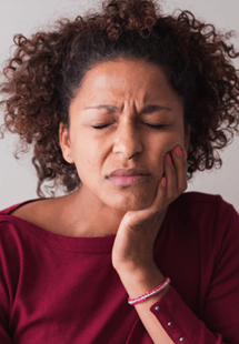 Woman with toothache sitting on couch at home