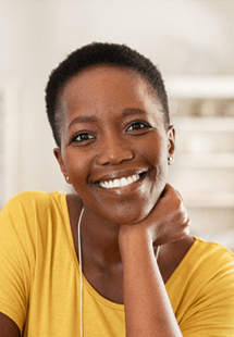 Woman in yellow shirt smiling at home