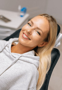 Patient reclined in treatment chair smiling