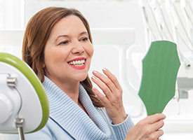 woman checking smile in green mirror