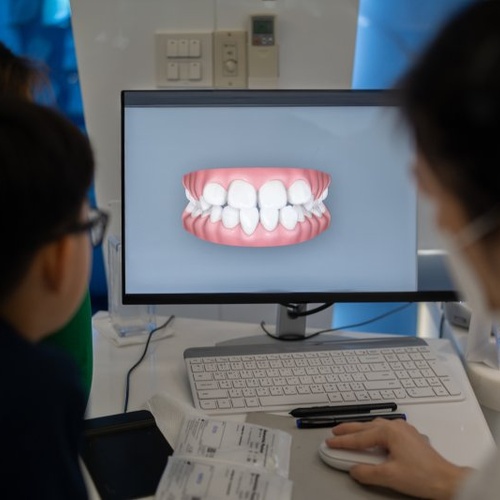 Dentist looking at a digital image of patient’s dental alignment 