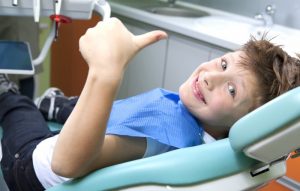 A young patient smiling at his dental exam.