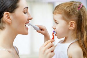 Mother and daughter brushing teeth