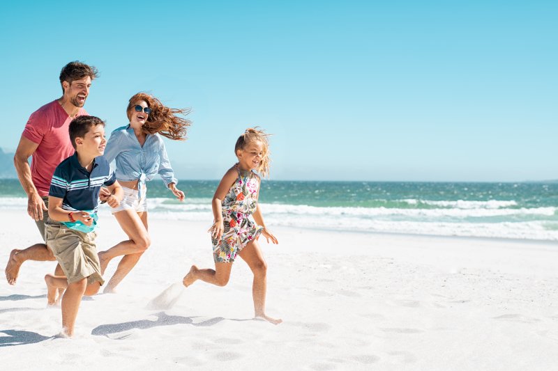 family running on the beach during summer vacation
