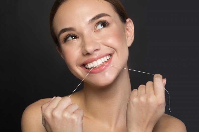woman flossing for New Year’s resolutions in Canton