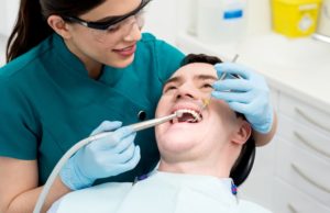 man getting teeth cleaned at dentist 