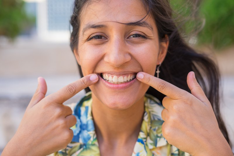 woman smiling and pointing at her teeth in Canton
