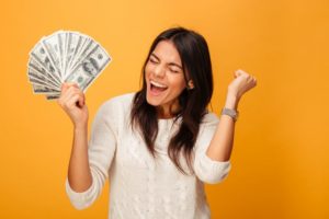 a woman smiling happily with her tax refund money