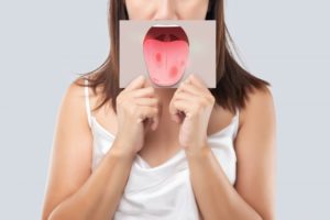 a woman holding up a picture of oral cancer