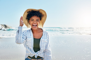 Woman on a beach laughing and smiling