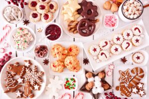 White table covered with holiday cookies, candies, and treats
