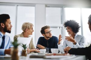 Diverse group of people smiling and working around a table